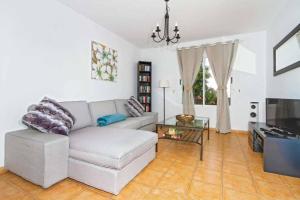 een woonkamer met een bank en een tv bij Villa Alcazar in Playa Blanca