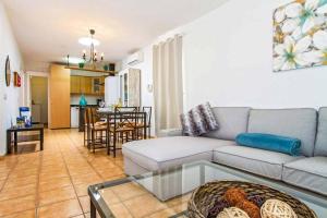 een woonkamer met een bank en een tafel bij Villa Alcazar in Playa Blanca