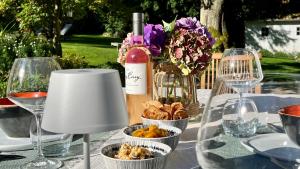 a table with a bottle of wine and some food at La Plonploniere in Aix-en-Issart