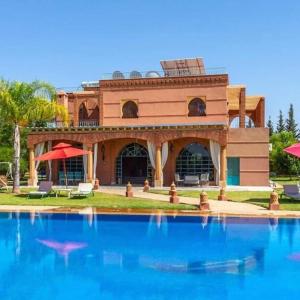a house with a swimming pool in front of it at Villa Dar Moudar in Marrakech