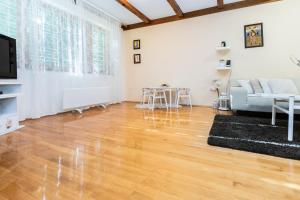 a living room with a wooden floor and a couch at Kuća za odmor Pristaš in Nova Gradiška