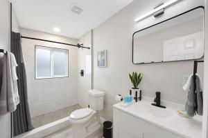 a white bathroom with a toilet and a sink at Palm Cove Motel in Clearwater