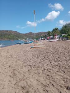 a sandy beach with boats in the water at llaves trancient 3 in Nasugbu