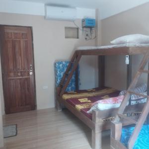 a room with two bunk beds and a door at llaves trancient 3 in Nasugbu