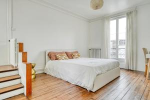 een witte slaapkamer met een bed en een raam bij Big Maison 20 min Paris & Disney in Saint-Maur-des-Fossés