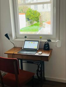 un ordenador portátil sentado en un escritorio frente a una ventana en Oporto historic center downtown, en Oporto