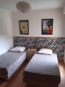 2 Betten in einem Zimmer mit zwei Plakaten an der Wand in der Unterkunft Eden Beach in Cannes