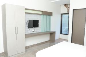 ein Schlafzimmer mit einem TV an einer weißen Wand in der Unterkunft HOTEL RAMJI in Karmād