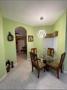 a dining room with a glass table and chairs at King Suite & Jacuzzi Luxe Getaway in Port St Lucie in Port Saint Lucie
