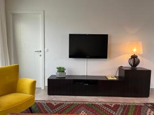 un salon avec une télévision et une chaise jaune dans l'établissement Penthouse 29, à Ostende