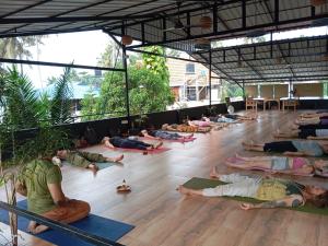 瓦尔卡拉Mad about Coco Yoga & Beach Retreat的一群人躺在地板上做瑜伽