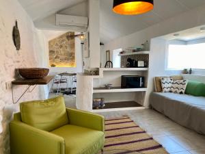 uma sala de estar com uma cadeira verde e um sofá em La Careza De Mijas - Adults Only em Mijas