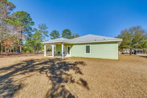 una pequeña casa verde con patio en Modern Gulf Breeze Home with Patio 13 Mi to Beach!, en Oriole Beach