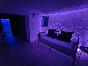 a living room with a couch in a purple room at BONITA CASA CUEVA CON JACUZZI in Paterna