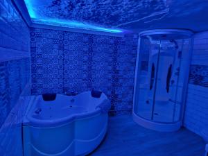 bagno con lavandino e doccia con luci blu di BONITA CASA CUEVA CON JACUZZI a Paterna