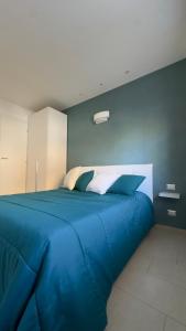 uma grande cama azul num quarto azul em the smerald 2.2 em Alghero