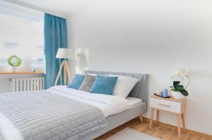 Mieszkanie do wynajęcia w centrum Kraśnika في كراسنيك: غرفة نوم مع سرير أبيض مع لهجات زرقاء