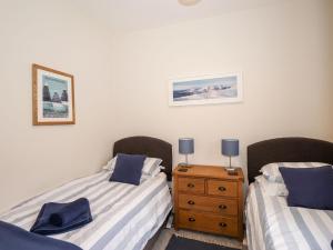 um quarto com 2 camas individuais e uma cómoda em madeira em Walla Crag, Royal Oak House em Keswick