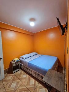 Hostal Arica 2 في أريكا: غرفة نوم فيها سرير وطاولة فيها