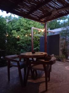 a wooden table and chairs under a pergola at L2 Bacalar in Bacalar