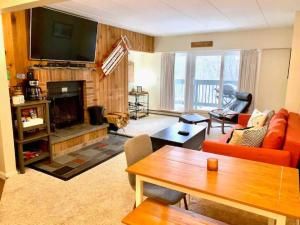 a living room with a couch and a fireplace at Mt Green, Pool, Gym, Sauna, Hot Tub Open 3br2b, in Killington