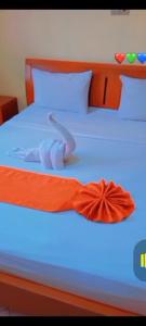 uma cama com uma fita laranja em Rockerz Grill B&B em Nairobi