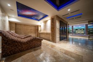 uma sala de estar com um sofá e uma televisão no tecto em Hotel Alexandar Lux em Podgorica