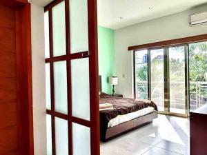 1 dormitorio con 1 cama y puerta corredera de cristal en Ubicación privilegiada con encanto local. en Cozumel