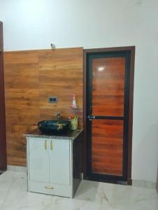 a bathroom with a sink and a wooden door at Kishore villa fully furnished house in Jaipur