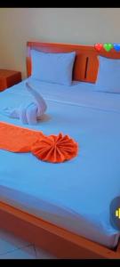 ein Bett mit orangefarbener Krawatte drauf in der Unterkunft Rockerz Grill B&B in Nairobi