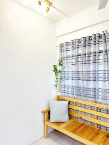 a bench in a room with a curtain at Backpackers Homestay - NomadsMNL in Manila