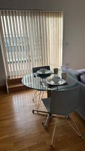 a glass table and chairs in a living room at Modern 2 bed flat with balcony in Southend-on-Sea