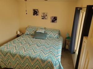 a bedroom with a bed with a blue pillow on it at Not Vegas, But Close Enough in Boulder City