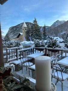 un gruppo di tavoli e sedie ricoperti di neve di Hotel Ristorante Il Principe a Claviere