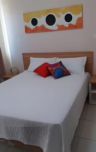 un letto bianco con due cuscini sopra di Thermas Do Bosque By Bnbhost a Caldas Novas