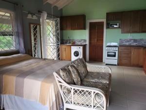 a room with a bed and a couch in a kitchen at Nia's Hillside Loft - Exquisite Views in Gros Islet
