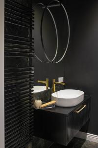 a bathroom with two sinks and a mirror at Srebrna Luxury Apartments - willa fabrykancka in Łódź