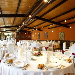 Un gran salón de banquetes con mesas y sillas blancas. en Hotel Marqués de la Moral, en Naveces