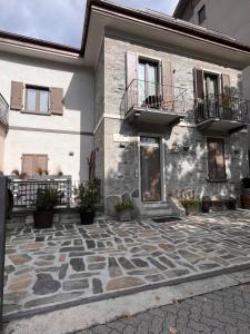 a building with two balconies and a stone courtyard at Stanza in sondrio Coel in Sondrio