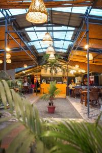 a restaurant with potted plants in the middle of a building at Mad about Coco Yoga & Beach Retreat in Varkala