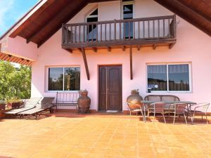 a patio with a table and chairs and a balcony at Bio Quinta do Pantano, Agro Turismo in Santo da Serra