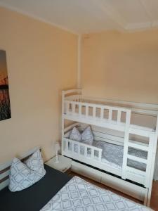 een slaapkamer met een wit stapelbed in een kamer bij Eichis Landliebe in Gorschendorf