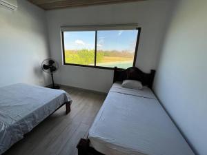 Tempat tidur dalam kamar di Tropical Hideaway with SharePool in Secure Condo, LIR