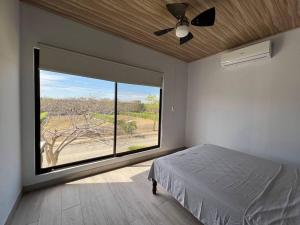 a bedroom with a bed and a large window at Tropical Hideaway with SharePool in Secure Condo, LIR in Guanacaste