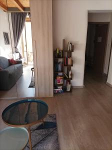 ein Wohnzimmer mit einem Couchtisch und einem Bücherregal in der Unterkunft Katane Apartment One-Room in Catania