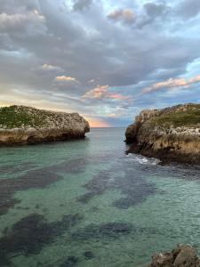 a view of the ocean with rocks in the water at Eco-Hostel La Casa Verde in poo de Llanes