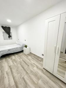 a white room with a bed and a closet at Apartments near metro in Madrid