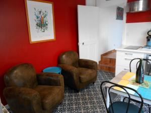 due sedie e un tavolo in una stanza con pareti rosse di Le Petit Dernier a Portbail