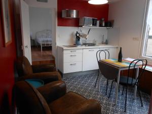 una cucina con tavolo e sedie in una stanza di Le Petit Dernier a Portbail