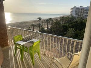 balcón con mesa y sillas y la playa en Beachfront and Cozy Apartment, en Cullera